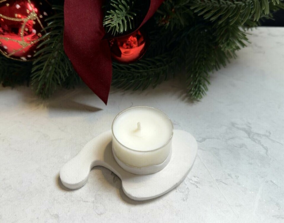 Nisselys i selvtørkende leire – en rustikk og personlig julepynt til hjemmet. (Foto: Kreative Ideer/ Aurora Lange) Et nisselys laget av selvtørkende leire med en enkel, hvit telysholder. Bakgrunnen består av grønt juletrepynt med røde ornamenter