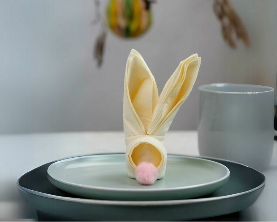 En brettet påskehare av serviett gir en sjarmerende detalj til påskebordet. En enkel og kreativ idé for en koselig borddekking. (Foto: Miriam Schjetlein)