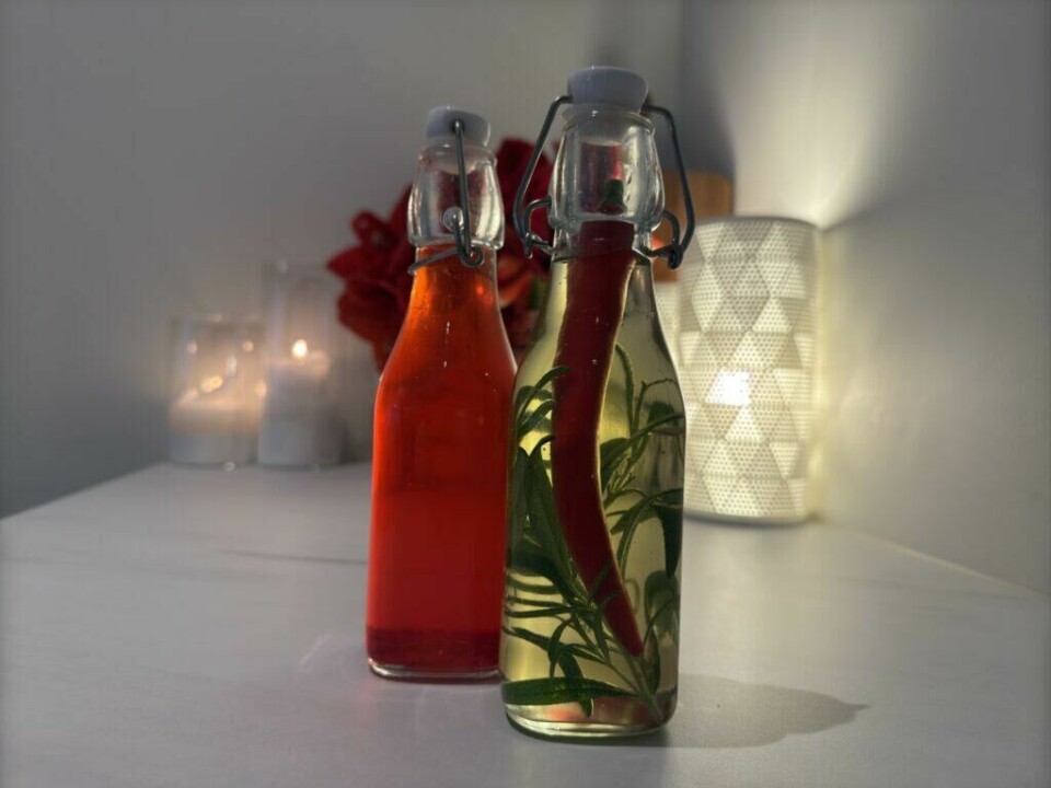 Dekorative flasker med hjemmelaget chili- og rosmarinolje og jordbærvinaigrette – enkle julegaver som imponerer. (Foto: Kreative Ideer/Aurora Lange)