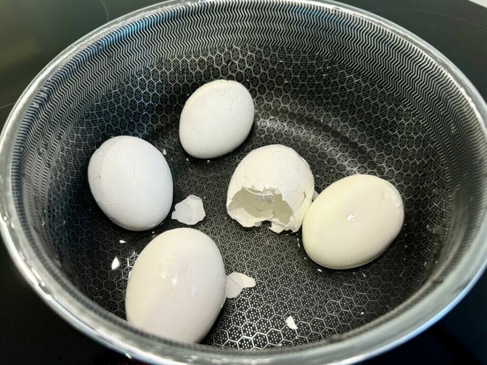 Egg: Ved å riste de kokte eggene forsiktig i kjelen sprekker skallene, noe som gjør det enkelt å skrelle flere egg samtidig på en rask og effektiv måte (Foto: Kreative Ideer/ Aurora) begynt å sprekke. Dette illustrerer et tips for å skrelle flere egg samtidig: ved å legge de kokte eggene tilbake i kjelen etter koking og riste dem forsiktig. Dette skaper små sprekker i skallene og gjør det enklere å fjerne dem. Teknikken lar deg skrelle flere egg på én gang, uten å måtte skrelle hvert egg individuelt.