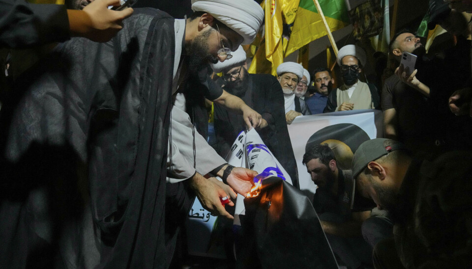 Irakiske demonstranter brenner det israelske flagget under en protest mot israelske angrep på flere byer i Iran. Protestene fant sted ved den såkalte grønne sonen hvor den amerikanske ambassaden ligger i Bagdad.