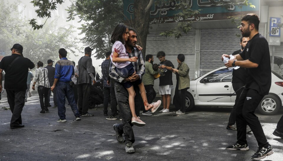 En såret jente bæres bort etter en eksplosjon i sentrum av Teheran under de israelske angrepene i helgen. Mange har siden flyktet fra den iranske hovedstaden.