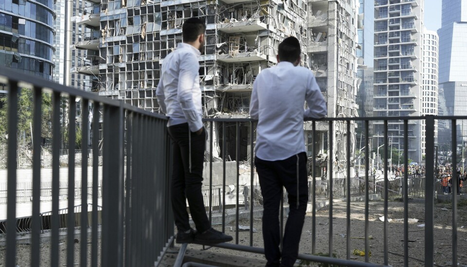 To menn observerer et bygg i Ramat Gan i Israel som ble truffet av en iransk rakett.
