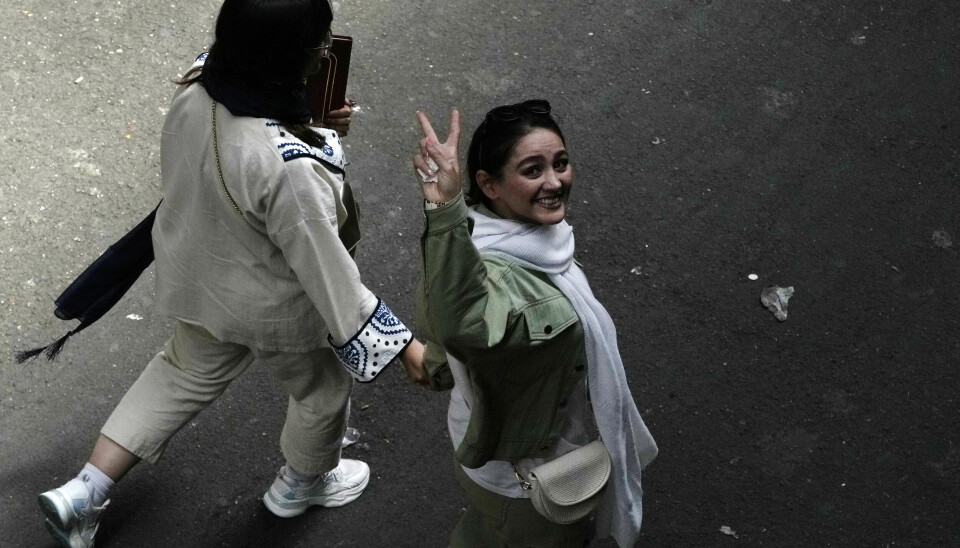 Fortsatt er det kvinner i Iran som trosser den strenge kleskoden og går uten hijab. Men konsekvensene kan bli alvorlige for de som ble tatt. Disse kvinnene viste seierstegn i juni 2024.