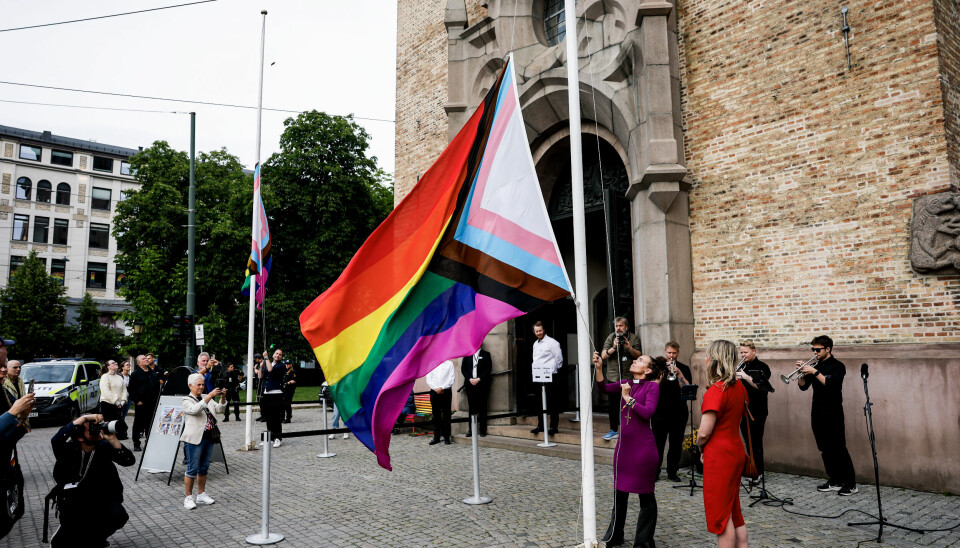 Oslobiskop Sunniva Gylver heiser regnbueflagget under åpningen av Oslo Pride 2025 foran Oslo domkirke.