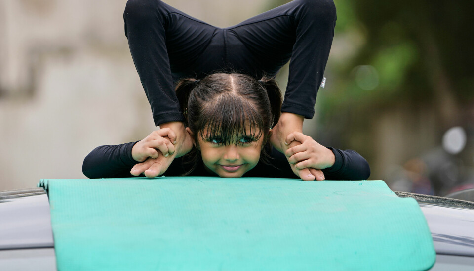 En jente praktisere yoga på et biltak i Ahmedabad i India.