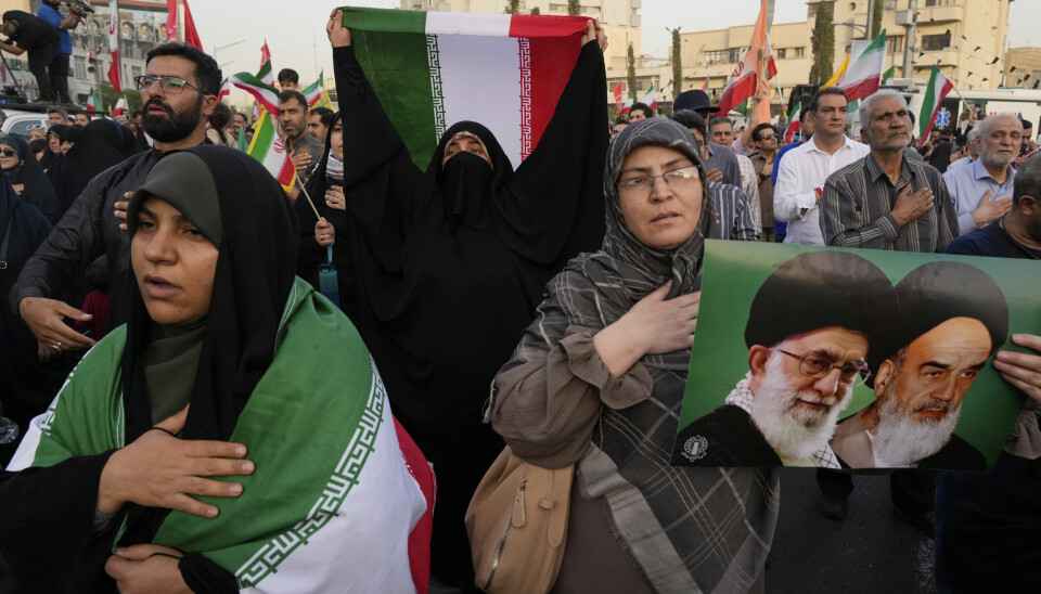 Iranske demonstranter med iranske flagg og et bilde at ayatolla Ali Khamenei og hans forgjenger Ruhollah Khomeini i Teheran tirsdag.