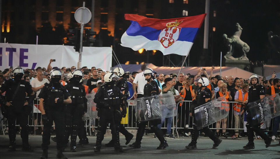 Politi med kraftig beskyttelsesutstyr er på plass ved demonstrantene i Beograd.