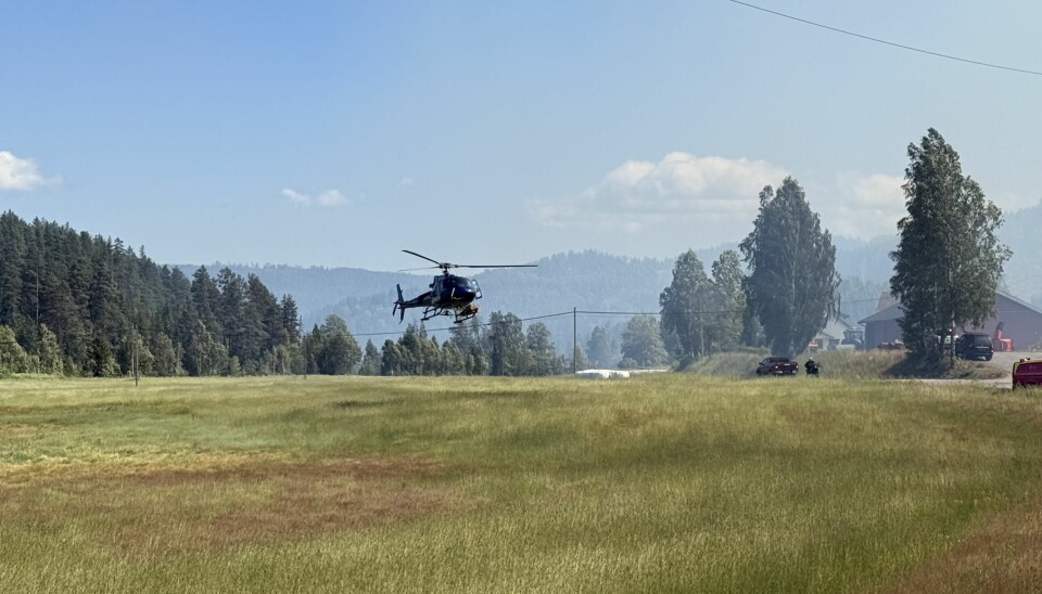 Brannhelikopter fra Geiteryggen i Skien bistår i slukkingsarbeidet.