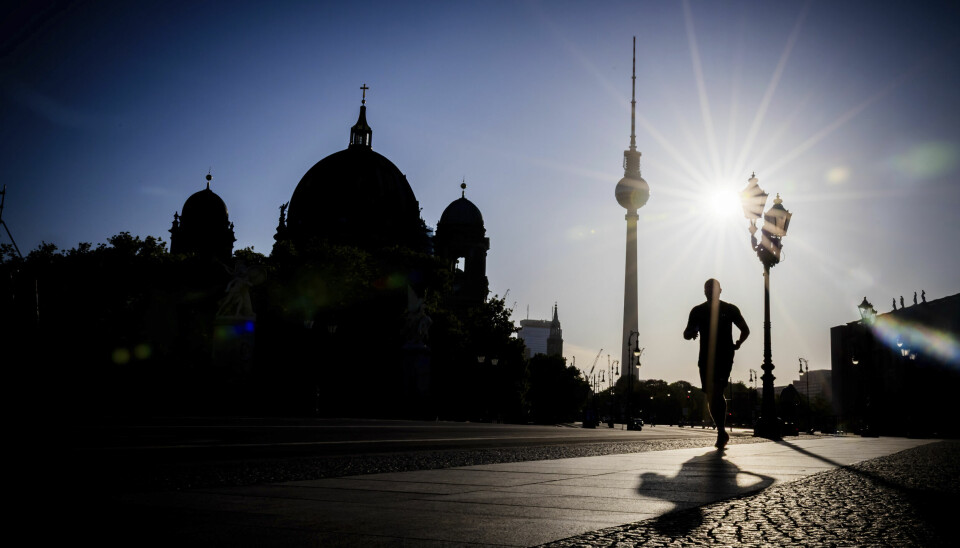 En person løper med Berlins TV-tårn og katedral i bakgrunnen.