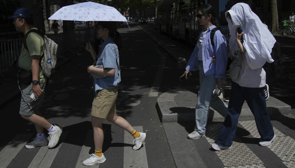 Turister i Paris søker ly fra solen.