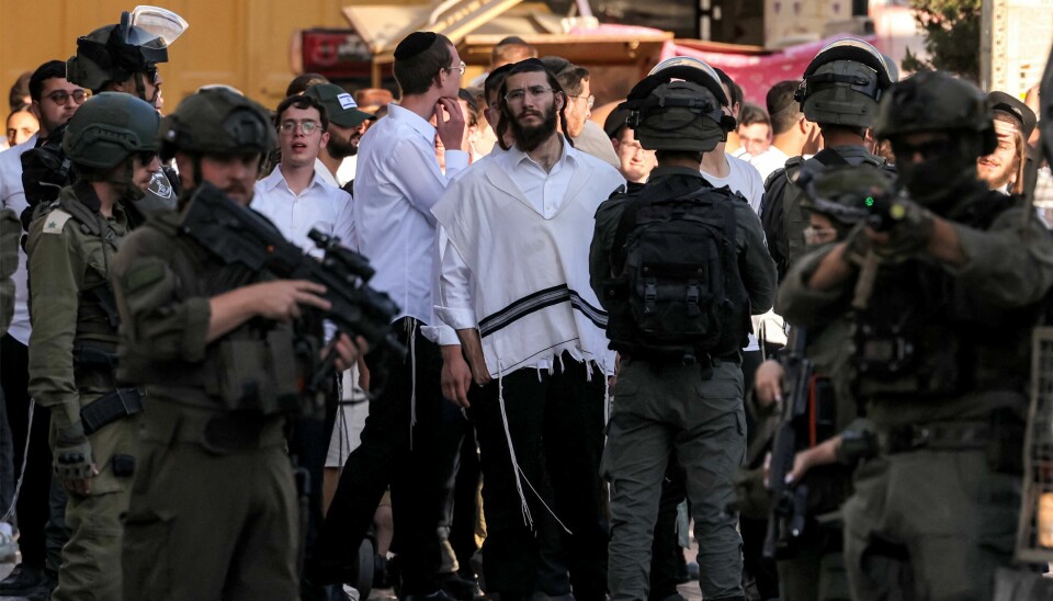 Israelske soldatar står vakt medan israelske jødiske busetjarar går gjennom den gamle marknaden i byen Hebron på den okkuperte Vestbreidda.