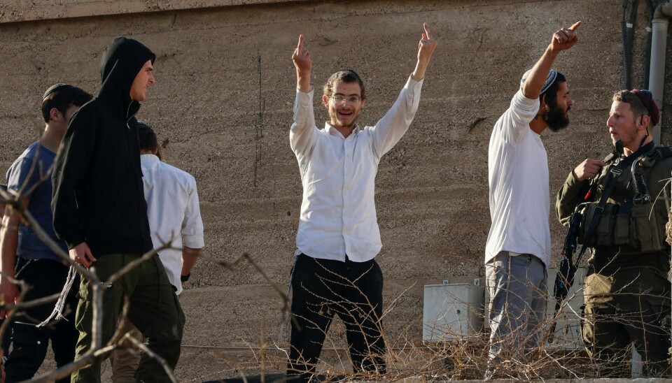 Israelske busetjarar viser fram langefingeren frå hustak medan dei hånar palestinske forbipasserande, nær Ibrahimi-moskeen medan israelarar markerer ei årleg religiøs høgtid i Hebron, på den okkuperte Vestbreidda.