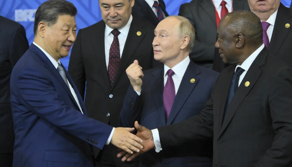 Kinas president Xi Jinping (t.v.) inngår stadig flere valutaavtaler med afrikanske land. Her håndhilser han på Sør-Afrikas president Cyril Ramaphosa. Russlands president Vladimir Putin står mellom om dem.