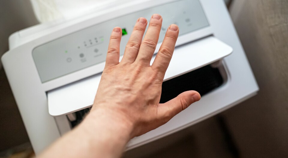 Portabel aircondition kan være svaret for deg som vil kjøle ned boligen kjapt, uten å måtte montere. Vi har funnet ut hvilke modeller eksperter i innland og utland kårer til best i test. En hånd holdes foran en portabel aircondition for å kjenne på luftstrømmen. Enheten har digitale knapper og står innendørs. Dette er portable airconditions som er kåret til best i test.