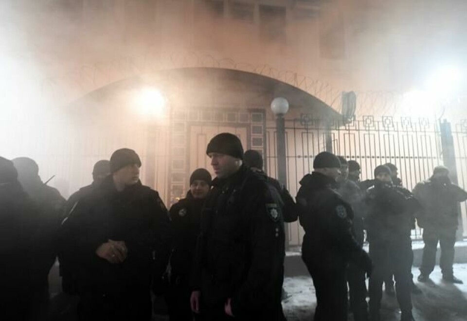 Politibetjenter foran den russiske ambassaden i Kiev 25. november. Røyk fra nødbluss demonstrantene tok i bruk. NTB Scanpix/AFP. Politibetjenter foran den russiske ambassaden i Kiev 25. november. Røyk fra nødbluss demonstrantene tok i bruk. NTB Scanpix/AFP.