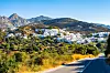 Utsikt over fjellandsbyen Kourounochori fra en svingete landevei, med hvitmalte hus spredt oppover åssiden på Naxos i Hellas.