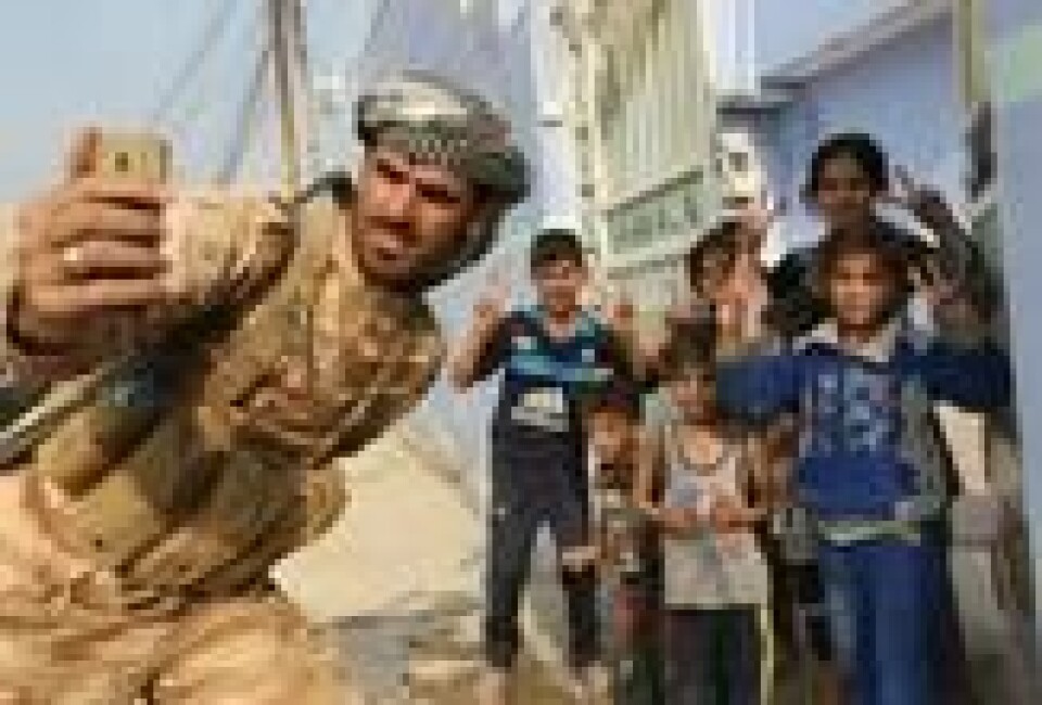 En kurdisk peshmergasoldat poserer sammen med barn etter gjenerobringen av landsbyen Fadiliya nord for Mosul. En kurdisk peshmergasoldat poserer sammen med barn etter gjenerobringen av landsbyen Fadiliya nord for Mosul. Foto: Ari Jalal / Reuters