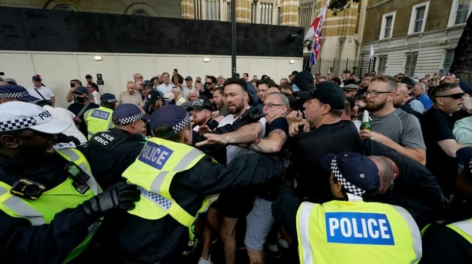 Politi og demonstranter støtte sammen på Whitehall like ved Downing Street i London onsdag kveld. Foto: Jordan Pettitt / PA / AP / NTB