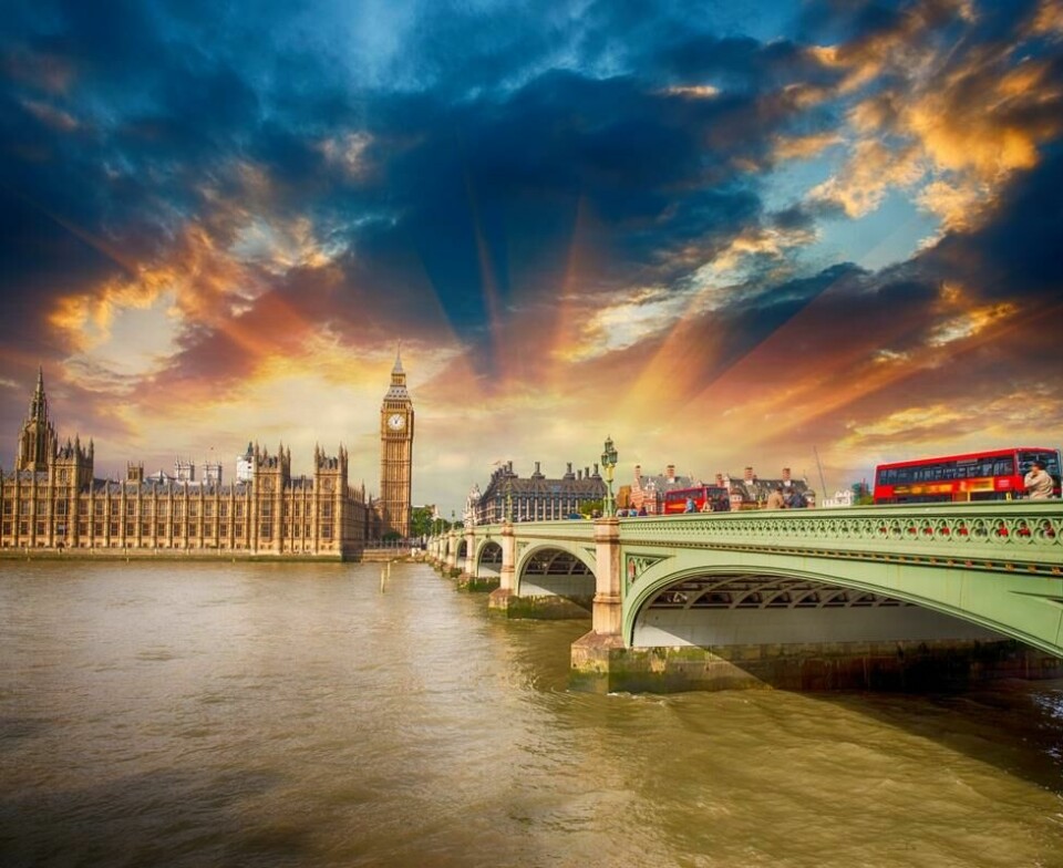 En rød dobbeltdekker krysser Westminster Bridge til Houses of Parliament i London. En rød dobbeltdekker krysser Westminster Bridge til Houses of Parliament i London. Foto: Colourbox