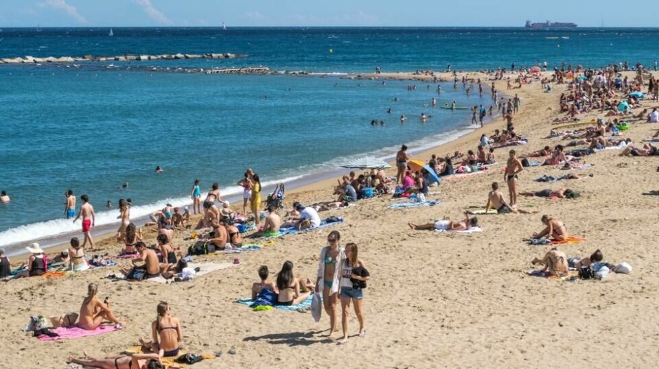 Illustrasjonsfoto: Turister på stranden i Barcelona i Spania.