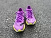 Et par løpesko fra Puma i lilla og gult står på asfalt, klare til bruk. Den lette og fargerike designen fremhever skoenes sporty preg, laget for løping og trening. Bildene understreker moderne joggesko med fokus på ytelse og komfort.