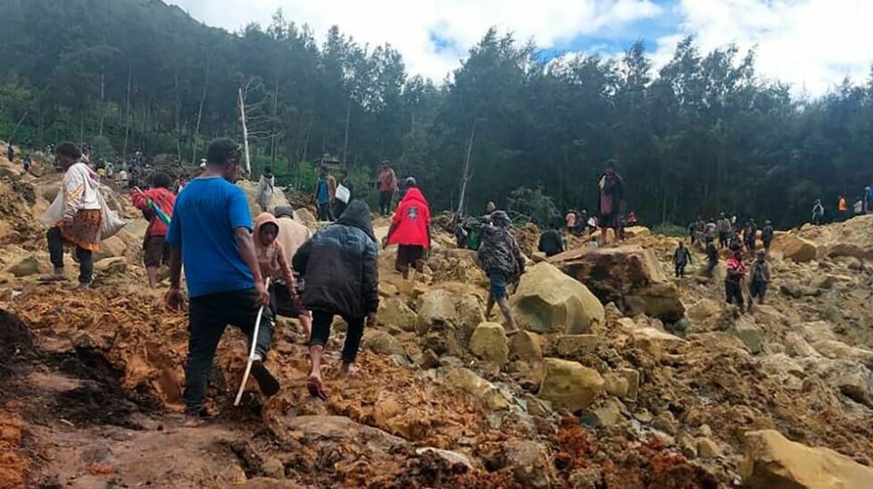 Folk på vei over skredet som kan ha kostet flere hundre mennesker livet i høylandet i Papua Ny-Guinea. Foto: Benjamin Sipa / International Organization for Migration / AP / NTB