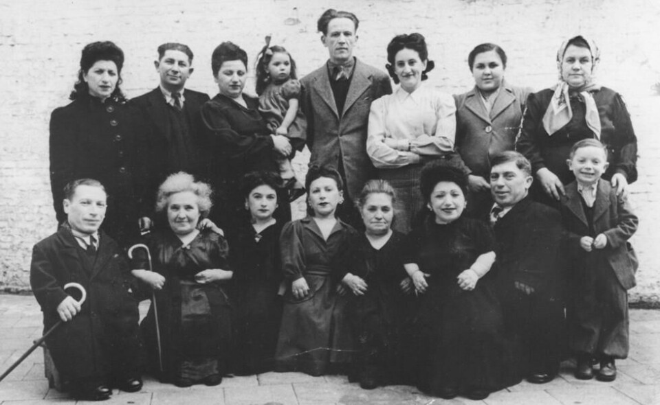 Hele familien Ovitz samlet i 1949. I forreste rekke, fra venstre til høyre, er Micki, Francesca, Perla, Elizabeth, Rozika, Frieda, Avram og Shimshon. Stående bak: Sarah, Azriel, hans hustru Leah som holder deres datter Batia, Moshe Moskowitz (Elizabeths ektemann), en ukjent kvinne, Avrams datter Batia og hennes mor Dora. Foto: United States Holocaust Memorial Museum / Yehuda Koren og Eilat Negev. Hele familien Ovitz samlet i 1949. I forreste rekke, fra venstre til høyre, er Micki, Francesca, Perla, Elizabeth, Rozika, Frieda, Avram og Shimshon. Stående bak: Sarah, Azriel, hans hustru Leah som holder deres datter Batia, Moshe Moskowitz (Elizabeths ektemann), en ukjent kvinne, Avrams datter Batia og hennes mor Dora. Foto: United States Holocaust Memorial Museum / Yehuda Koren og Eilat Negev.