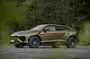 Sideprofil av en gullfarget Lamborghini Urus SE parkert i naturmiljø. Lamborghini Urus SE, luksus-SUV, design.