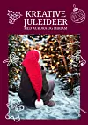 Forsiden på Kreative Ideer sin julebok i 2025. Liten jente med stor nisselue.