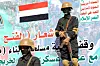 Soldatene på bildet er Houthi-lojale krigere som står vakt under en demonstrasjon i solidaritet med Palestina. På plakaten bak står det skrevet «død over USA. Død over Israel», ifølge nyhetsbyrået AFP. Foto: Mohammed Huwais / AFP / NTB