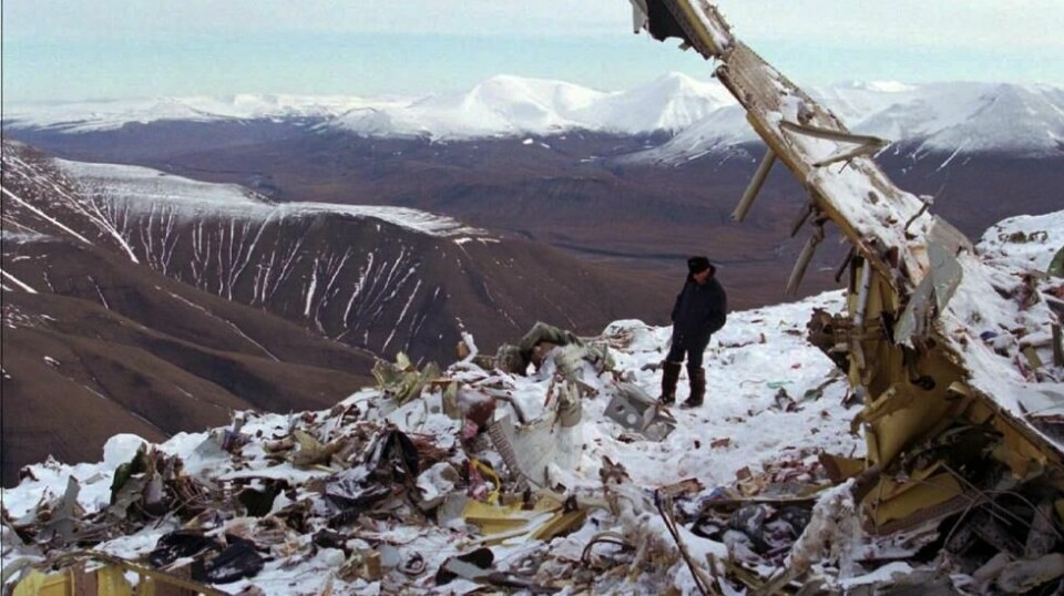 En russer går blant vrakrestene og leter etter eiendeler til sine kjære blant restene etter flyvraket på toppen av Operafjellet i august 1996. (NTB-foto: Aleksander Nordahl) / Svalbard / Ulykker / Flyulykker / Russland / Vrak / Flyvrak /