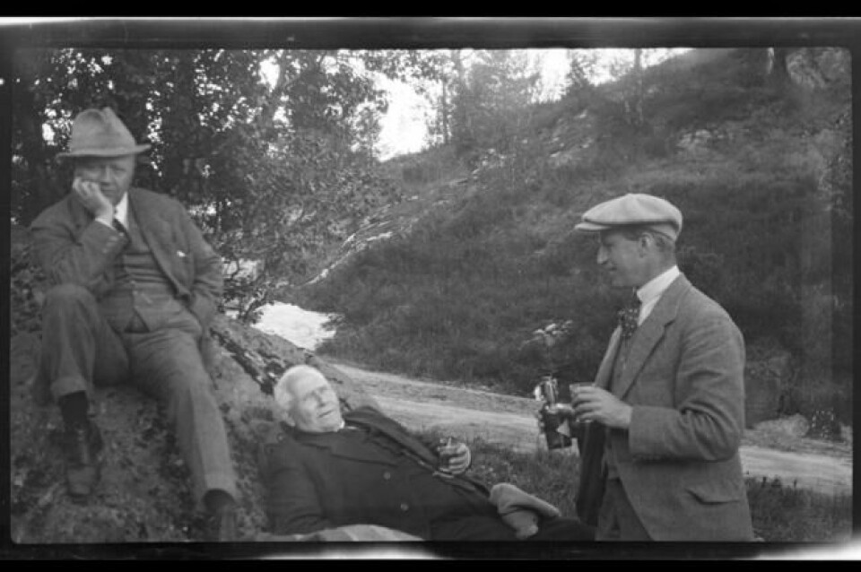 Tre menn ved en vei som skal hygge seg med noe sterkt i glasset. Bilde fra 1922. Tre menn ved en vei som skal hygge seg med noe sterkt i glasset. Bilde fra 1922. Foto: Sundt, Rolf Sr. / Oslo Museum