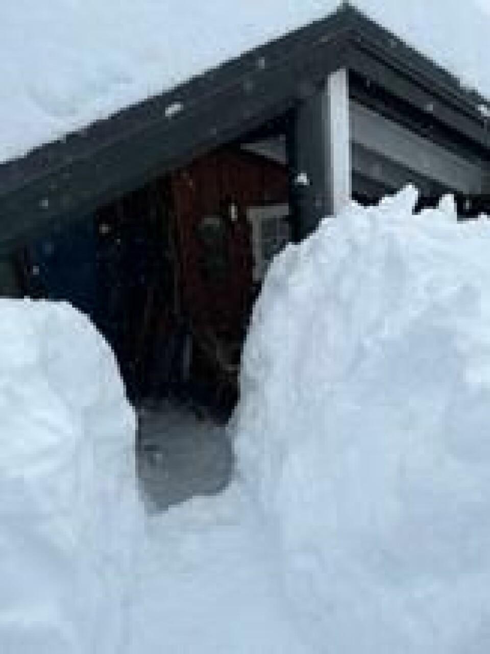 Når du måker hyttetaket må du ikke velte snøen ned foran inngangsdøren. Måk vei nok til at du enkelt kommer deg ut hvis du trenger døren som rømningsvei. Når du måker hyttetaket må du ikke velte snøen ned foran inngangsdøren. Måk vei nok til at du enkelt kommer deg ut hvis du trenger døren som rømningsvei. Foto: Marius Solberg Anfinsen / Frende Forsikring