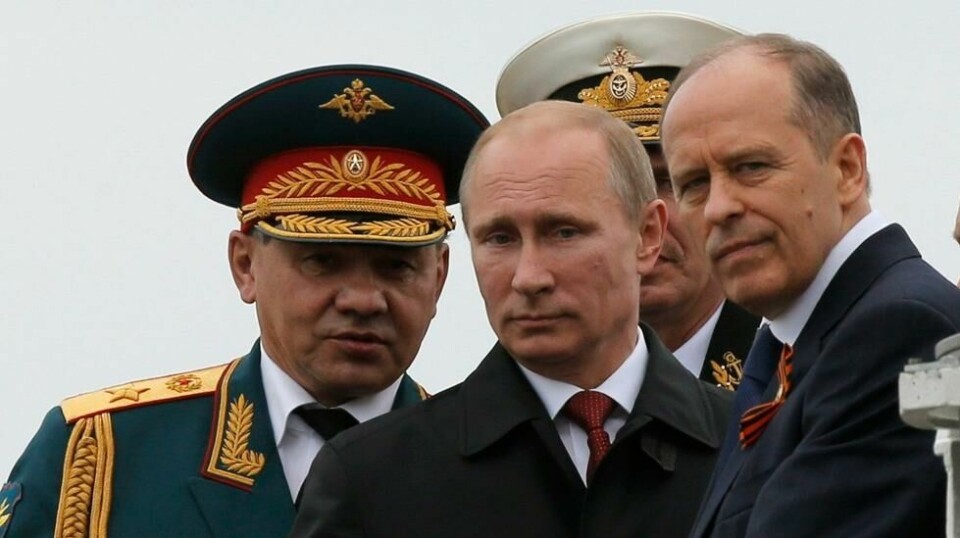 Vladimir Putin sammen med Russlands forsvarsminister Sergej Sjojgu (t.v) og FSB-sjef Alexander Bortnikov. Foto: Maxim Shemetov / Reuters / NTB