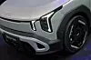 Frontdetalj av Kia Niro EV med LED-lykter og felg på en utstilling.