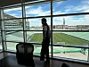 Person står ved panoramavindu og ser ut over en tom fotballstadion.