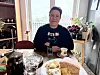 Karen ved spisebordet: Mexicanske Karen sitter ved et spisebord med kaffe, vann og kake foran seg, med store vinduer og grønne planter i bakgrunnen. Da hun flyttet til Norge begynte hun med lysterapi som behandling av vinterdepresjon.