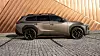 Bronse Lexus SUV i sideprofil foran vegg med diagonale metallpaneler