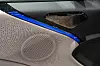 Bildørpanel med perforert høyttaler og blå lyslist i et moderne bilinteriør. De to dyreste variantene har et stereoanlegg på hele 2.160 watt med 23 høyttalere.