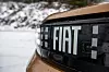 Nærbilde av Fiat-logo på bilfront med snø i bakgrunnen. Fiat legger ikke skjul på merkenavnet, blant annet på dekselet for ladeluken til ombordladeren.