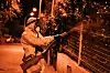 Arbeider i vernedrakt sprøyter myggmiddel langs gjerde i en gate i Nice om natten