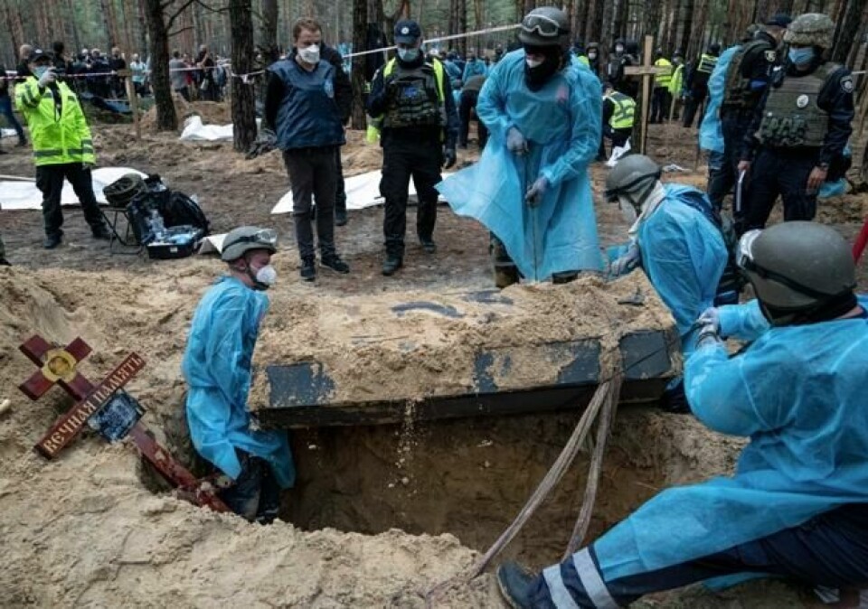 Ukrainsk personell henter opp en kiste med levninger ifra massegravstedet i Izium. Ukrainske myndigheter sier noen av likene bærer preg av å ha blitt utsatt for tortur. Foto: Jevhen Maloletka / AP / NTB Ukrainsk personell henter opp en kiste med levninger ifra massegravstedet i Izium. Ukrainske myndigheter sier noen av likene bærer preg av å ha blitt utsatt for tortur. Foto: Jevhen Maloletka / AP / NTB