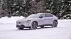 Lys Volvo ES90 elbil kjøres på snødekt vei foran mørk skog om vinteren. Å kjøre en Volvo ES90 Ultra RWD er en drøm, men noe mangler, spesielt på vinterføre.