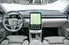 Lyst Volvo ES90-interiør med stort portrettorientert infotainmentdisplay og ratt foran snødekt bakgrunn. Volvo forsvarer det minimalistiske og rene designet med solide materialer og en elegant og praktisk utforming.