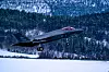F-35 kampfly tar av fra snødekt rullebane foran skogkledd åsside