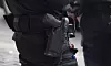 Nærbilde av politibetjent med pistol i hylster og utstyrsbeltet på gata