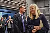 Kronprins Haakon og kronprinsesse Mette-Marit går gjennom en industripreget hall omgitt av pressefolk.