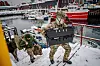 Danske soldater i vinteruniform bærer utstyr opp en snødekt trapp ved havnen i Nuuk.