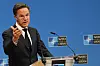 Mark Rutte taler ved en NATO-podium foran blå bakgrunn med NATO-logoer.